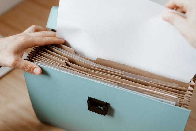 person putting documents in file