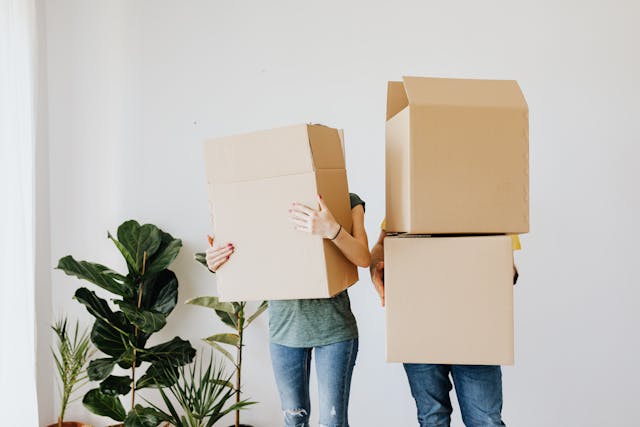 two people holding moving boxes