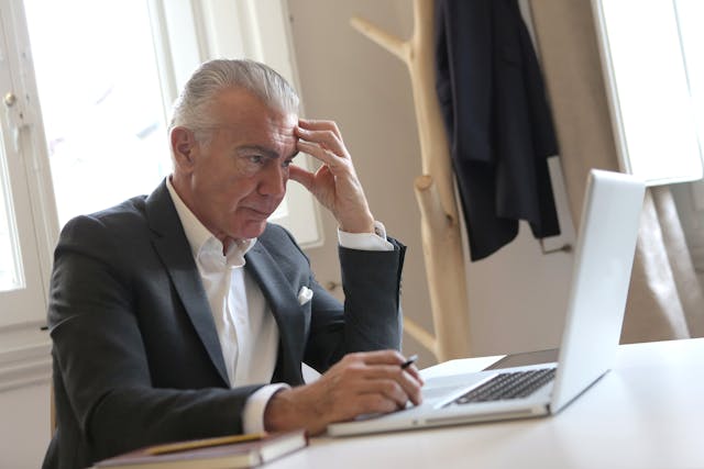 stressed man in suit at computer